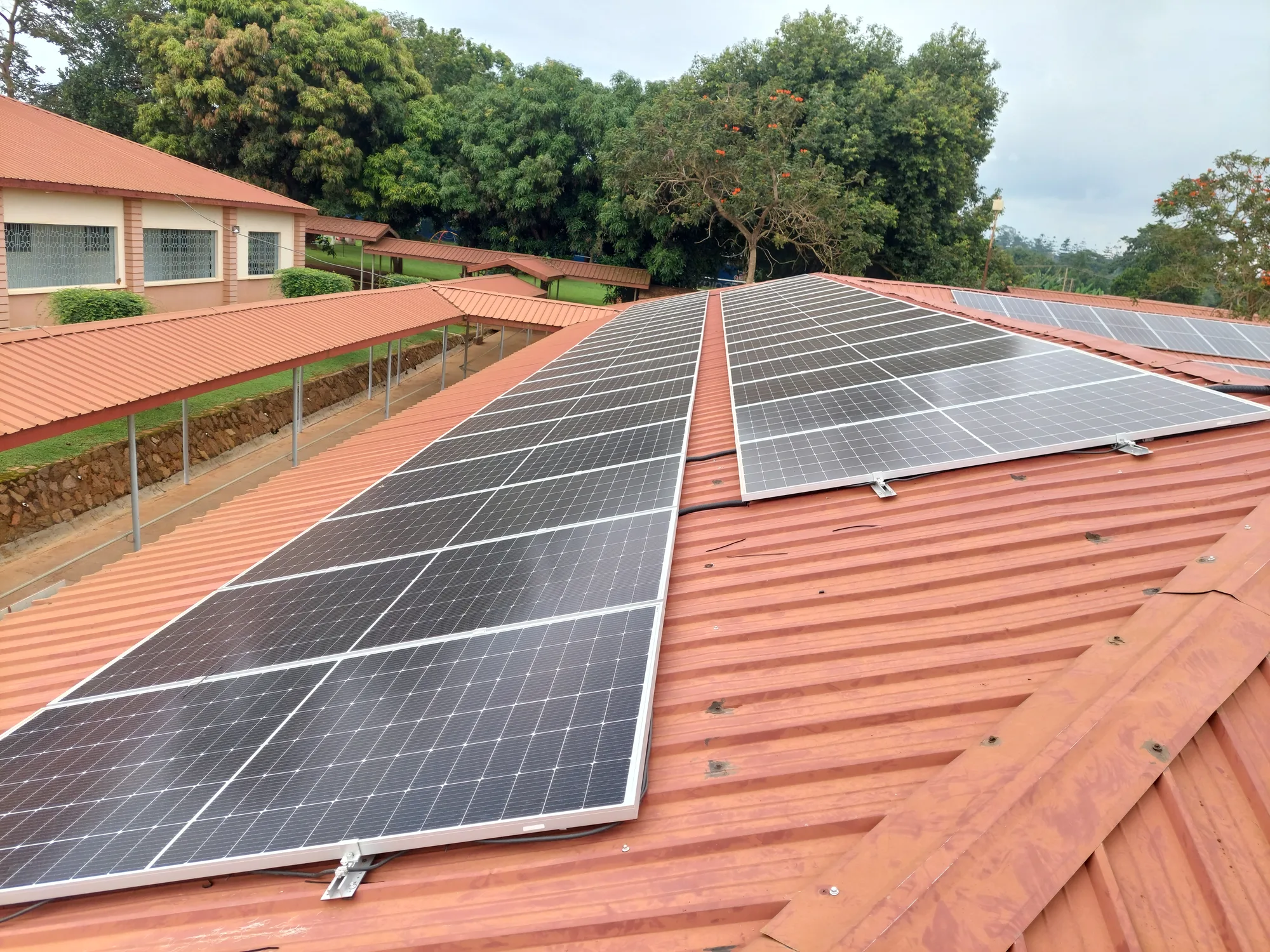Equator Solar technician on scheduled service visit at a rooftop solar power system in Uganda