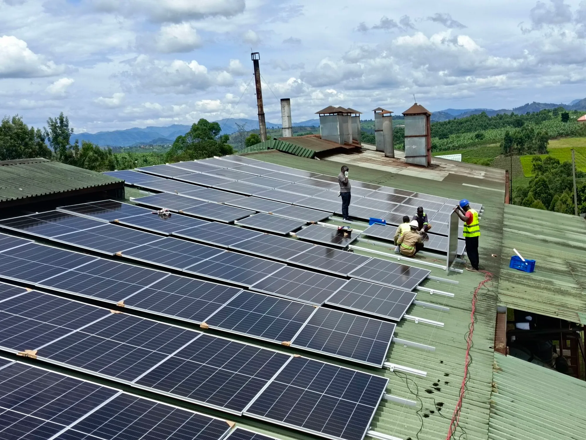 Aerial view of Equator Solar engineers installing a rooftop solar power system at Kyamuhunga Tea Factory in Bushenyi, Uganda